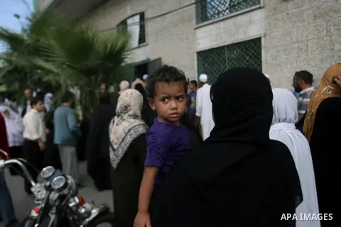 Palestinians wait in front of a center for Social Affairs to receive the financial aid during the program of the Ministry of Social Affairs to help the people with special needs, in Rafah in southern Gaza strip, Oct. 07,...