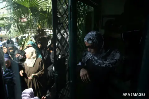 Palestinians wait in front of a center for Social Affairs to receive the financial aid during the program of the Ministry of Social Affairs to help the people with special needs, in Rafah in southern Gaza strip, Oct. 07,...
