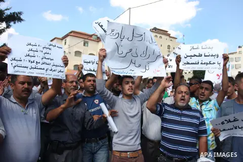 Palestinian workers demonstrate in front of the Council of Ministers during a protest the value of the minimum wage 1450 shekels, in the West Bank city of Ramallah, on Oct. 09, 2012. Photo by Issam Rimawi