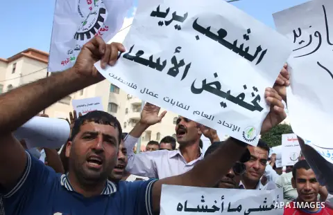 Palestinian workers demonstrate in front of the Council of Ministers during a protest the value of the minimum wage 1450 shekels, in the West Bank city of Ramallah, on Oct. 09, 2012. Photo by Issam Rimawi