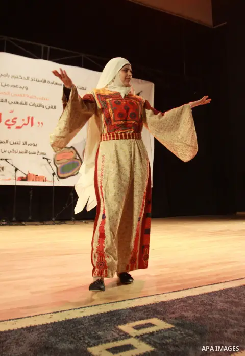 A Palestinian girl wears folk costumes during a traditional costumes show in the West Bank city of Nablus, Oct. 09, 2012. Traditional Palestinian costumes reflected a woman's economic and marital status and her town or d...