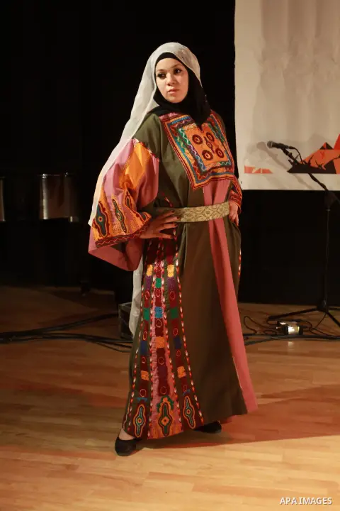 A Palestinian girl wears folk costumes during a traditional costumes show in the West Bank city of Nablus, Oct. 09, 2012. Traditional Palestinian costumes reflected a woman's economic and marital status and her town or d...