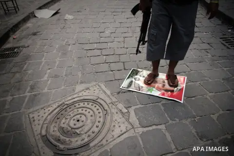 A Syrian rebel fighter stands on a picture of Syrian President Bashar al-Assad, in the Old Town of Aleppo, September 11, 2012 during clashes with Syrian government forces to retake control of the large Hanano army base i...