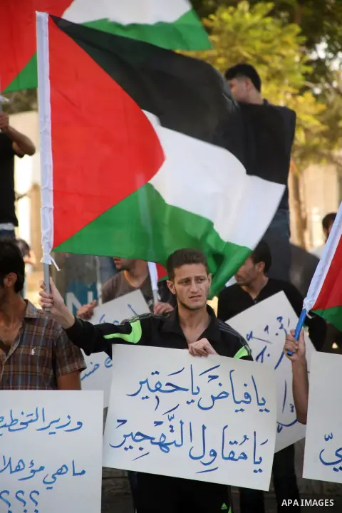 Palestinian protesters hold placards and shout slogans during a demonstration against the financial politics of Prime Minister Salam Fayyad and the high cost of living, in the West Bank city of Hebron, on Oct. 10, 2012....