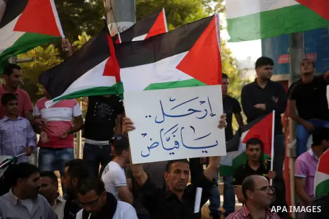 Palestinian protesters hold placards and shout slogans during a demonstration against the financial politics of Prime Minister Salam Fayyad and the high cost of living, in the West Bank city of Hebron, on Oct. 10, 2012....