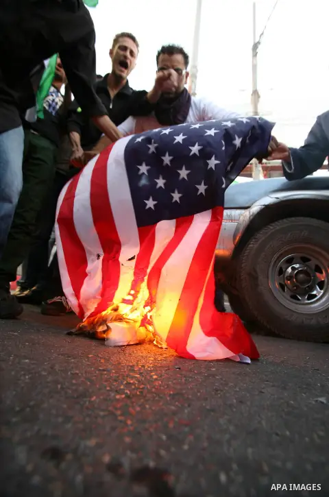 Palestinian protesters burn the US flag and pictures of Palestinian Prime Minister during a demonstration against the financial politics of Prime Minister Salam Fayyad and the high cost of living, in the West Bank city o...