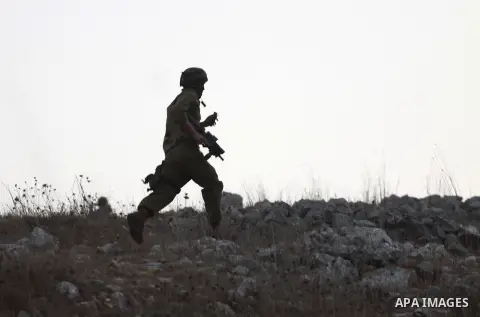 An Israeli soldier run after Palestinian farmers during clashes with Jewish settlers in the village of Burin near the West Bank city of Nablus on Oct. 10, 2012. Photo by Nedal Eshtayah