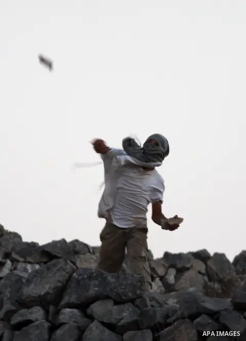 Israeli settlers from Bracha settlement throw stones at Palestinian farmers from the West Bank village of Burin, north of Nablus, during clashes on October 10, 2012. Over 100 olive trees belonging to Palestinians in a We...