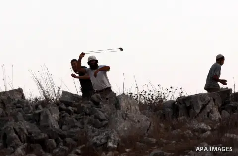 Israeli settlers from Bracha settlement throw stones at Palestinian farmers from the West Bank village of Burin, north of Nablus, during clashes on October 10, 2012. Over 100 olive trees belonging to Palestinians in a We...