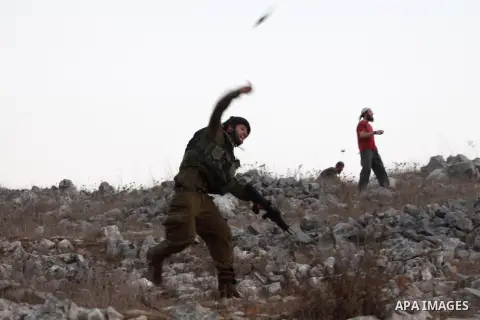 Israeli settlers from Bracha settlement throw stones at Palestinian farmers from the West Bank village of Burin, north of Nablus, during clashes on October 10, 2012. Over 100 olive trees belonging to Palestinians in a We...