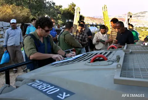 Israeli soldiers check Palestinians Identities as they make their way to harvest olive trees on the outskirts of the West Bank village of Salem, near the Jewish settlement of Elone Moreh, east of Nablus October 11, 2012....