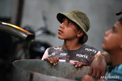 Palestinian children stand near olive press during producing olive oil in Gaza city on Oct. 12,2012 during the olive harvesting season. Agriculture is a major sector of the Palestinian economy, employing a large part Pal...