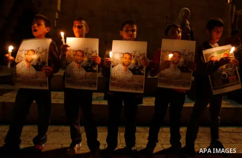 Palestinian children hold pictures of prisoners and candles during a protest calling for the release of Palestinian prisoners from Israeli jails and in support of inmates on hunger strike, outside Damascus Gate in Jerusa...