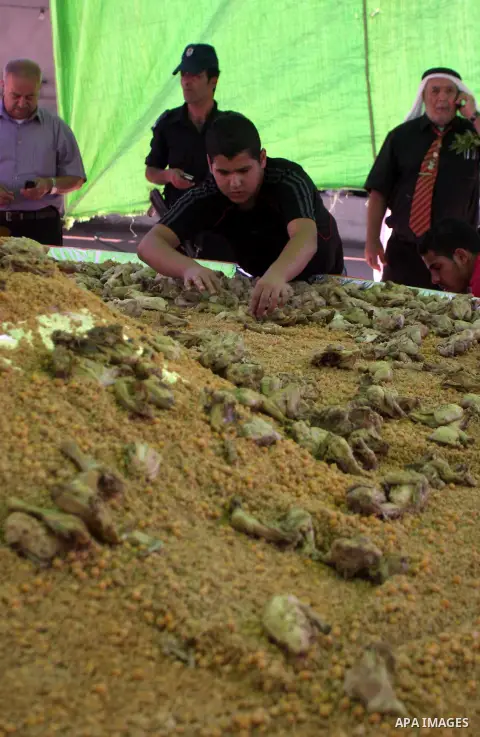 Palestinians participate in the festival largest "Couscous" dish (5 meters), a traditional Palestinian food, in the West Bank city of Ramallah, on Oct. 13, 212. Photo by Issam Rimawi