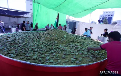 Palestinians participate in the festival largest "Couscous" dish (5 meters), a traditional Palestinian food, in the West Bank city of Ramallah, on Oct. 13, 212. Photo by Issam Rimawi
