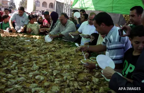 Palestinians participate in the festival largest "Couscous" dish (5 meters), a traditional Palestinian food, in the West Bank city of Ramallah, on Oct. 13, 212. Photo by Issam Rimawi