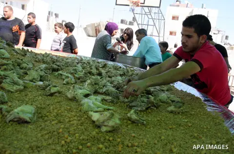 Palestinians participate in the festival largest "Couscous" dish (5 meters), a traditional Palestinian food, in the West Bank city of Ramallah, on Oct. 13, 212. Photo by Issam Rimawi