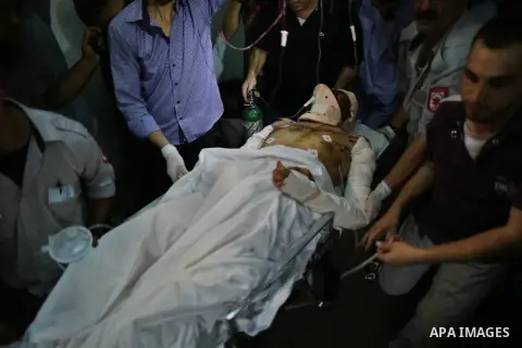 Palestinian health workers wheel a wounded man at Kamal Odwan hospital in northen Gaza strip following an Israeli airstrike in northern town of Jabaliya, in the Gaza Strip, on October 13, 2012. The air strike killed one...