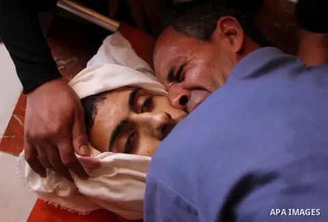 GAZA, Oct. 14, 2012 A relative mourns over the body of Palestinian militant Yaser Attal during his funeral in southern Gaza Strip city of Khan Yunis, on Oct. 14, 2012. He was killed by an Israeli air strike while he was...