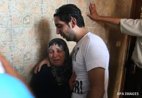 Palestinian relatives mourn over the body of Yasser Al Attal during his funeral in Khan Younis, southern Gaza Strip,on October 14, 2012. An Israeli air strike Saturday on the Gaza Strip has killed the coastal enclave's m...