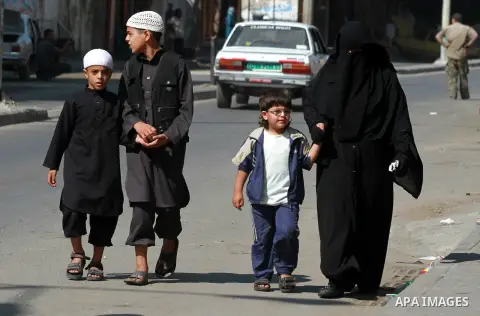 Palestinians walk during his funeral procession at Al-Bureij refugee camp in the central Gaza Strip, on October 14, 2012. Saedini, a top Salafist leader whose Islamist faction has recently fired rockets at Israel was amo...