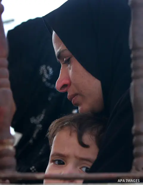 Relatives of Palestinian militant Mohammed Abu Ftair cover their ears as militants shoot in the air during his funeral in Deir al-Balah in central Gaza Strip October 15, 2012. An Israeli air strike in the central Gaza St...