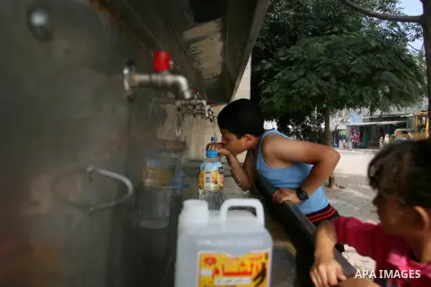 Palestinian children fill plastic bottles with drinking water in Rafah camp southern Gaza Strip, on Oct. 16, 2012. The residents of the Gaza strip suffer from lack of potable water, Israel continues to tighten its blocka...