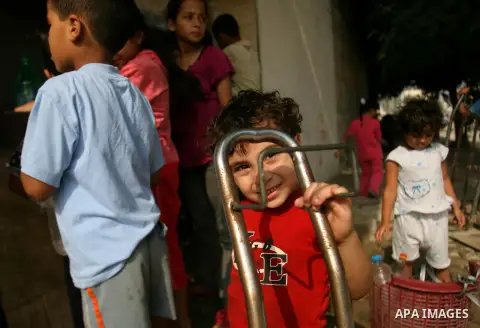 Palestinian children fill plastic bottles with drinking water in Rafah camp southern Gaza Strip, on Oct. 16, 2012. The residents of the Gaza strip suffer from lack of potable water, Israel continues to tighten its blocka...