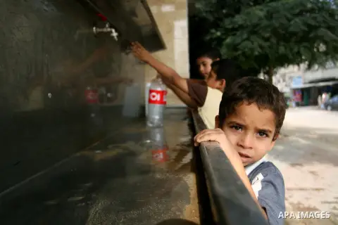 Palestinian children fill plastic bottles with drinking water in Rafah camp southern Gaza Strip, on Oct. 16, 2012. The residents of the Gaza strip suffer from lack of potable water, Israel continues to tighten its blocka...