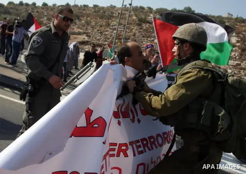 An Israeli border police officer,and an activist argue during a protest on highway 443 near the West Bank village of Beit Ur against what they say are attacks by Jewish settlers on Palestinians and their property, Octobe...