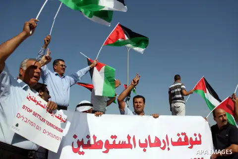 Activists hold Palestinian flags in front of Israeli troops during a protest on highway 443 near the West Bank village of Beit Ur against what they say are attacks by Jewish settlers on Palestinians and their property, O...