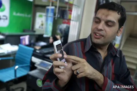 A Palestinian man holds Apple's new iPhone 5 at a mobile phone store in Gaza City on October 16, 2012. Apple's new iPhone 5 is selling well in the Gaza Strip despite inflated prices, reaching the Palestinian enclave via...