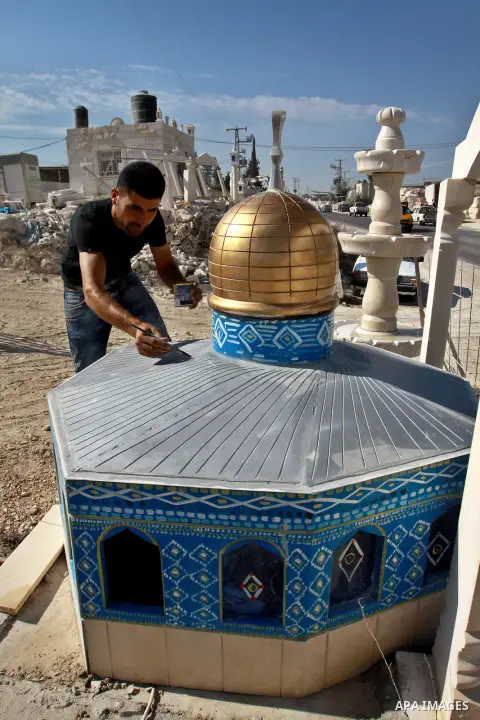 A Palestinian artist colors a model of the Dome of the Rock mosque made by marble stones, in the West Bank city of Nablus on Oct. 17, 2012. Photo by Nedal Eshtayah