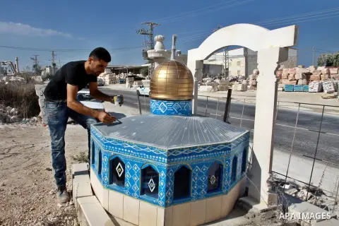 A Palestinian artist colors a model of the Dome of the Rock mosque made by marble stones, in the West Bank city of Nablus on Oct. 17, 2012. Photo by Nedal Eshtayah