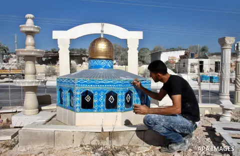 A Palestinian artist colors a model of the Dome of the Rock mosque made by marble stones, in the West Bank city of Nablus on Oct. 17, 2012. Photo by Nedal Eshtayah