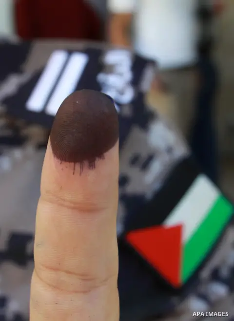 A member of the Palestinian security forces displays his finger after casting his vote during local elections at a polling station in the West Bank city of Jenin, on October 18,2012. Members of Palestinian security force...