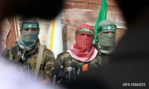 Abu Obaida (C), the spokesman for the Ezzedine Al-Qassam Brigades, the armed wing of Hamas, speaks during a news conference on October 18, 2012 at the Rafah border crossing with Egypt in the southern Gaza Strip to mark t...