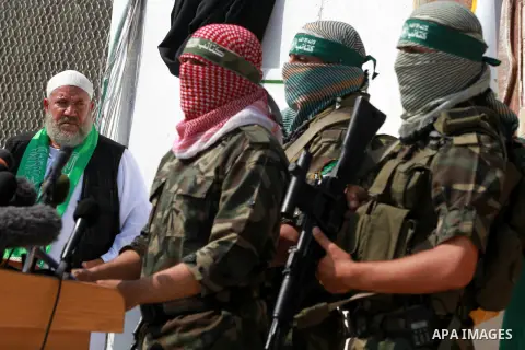 Abu Obaida (C), the spokesman for the Ezzedine Al-Qassam Brigades, the armed wing of Hamas, speaks during a news conference on October 18, 2012 at the Rafah border crossing with Egypt in the southern Gaza Strip to mark t...