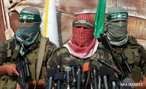 Abu Obaida (C), the spokesman for the Ezzedine Al-Qassam Brigades, the armed wing of Hamas, speaks during a news conference on October 18, 2012 at the Rafah border crossing with Egypt in the southern Gaza Strip to mark t...