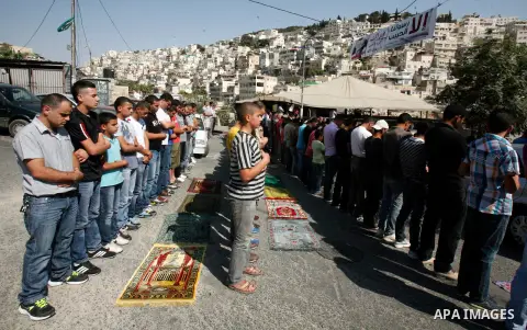 Palestinian Muslim worshippers attend Friday prayers outside a protest tent against the continuing 'Judaization of Jerusalem' by Jewish settlers, in the mostly Arab neighbourhood of Silwan in east Jerusalem on Oct. 19, 2...