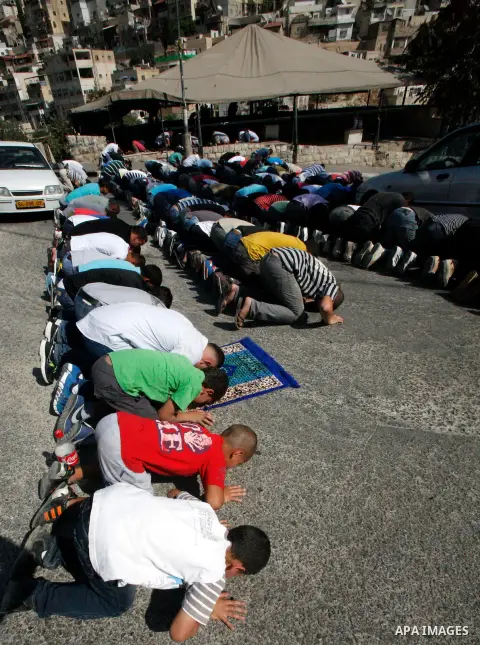 Palestinian Muslim worshippers attend Friday prayers outside a protest tent against the continuing 'Judaization of Jerusalem' by Jewish settlers, in the mostly Arab neighbourhood of Silwan in east Jerusalem on Oct. 19, 2...