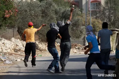 Palestinian protesters throw stones on towards Israeli soldiers during clashes following a demonstration against the expropriation of Palestinian land by Israel in the village of Kfar Qaddum, near the occupied West Bank...