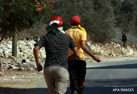 Palestinian protesters throw stones on towards Israeli soldiers during clashes following a demonstration against the expropriation of Palestinian land by Israel in the village of Kfar Qaddum, near the occupied West Bank...