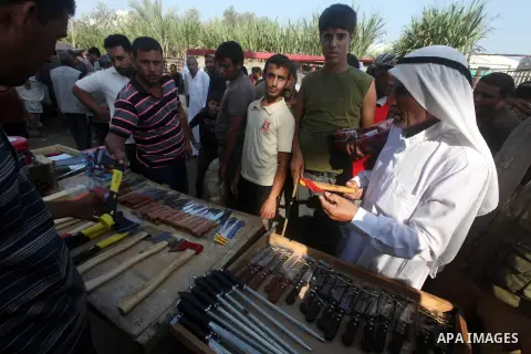 Palestinians buy knifes and axes at a local cattle market ahead of Muslim festival of Eid al-Adha, in Gaza city, on October 19, 2012. Muslims around the world prepare to celebrate Eid Al-Adha, which according to the luna...
