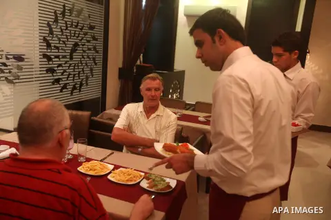 A Palestinian waiter serves a meal on October 18, 2012 at the first restaurant that employs deaf people in Gaza, which officially opened earlier this week in Gaza city. The restaurant was launched by Atfaluna Society for...