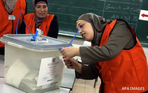 A Palestinian poll official empties a ballot box to start counting the votes at a polling station in the West Bank city of Ramallah on October 20, 2012. Polling stations were closed in the West Bank after 12 hours of vot...