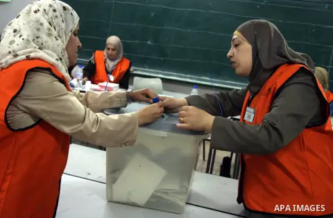 A Palestinian poll official empties a ballot box to start counting the votes at a polling station in the West Bank city of Ramallah on October 20, 2012. Polling stations were closed in the West Bank after 12 hours of vot...