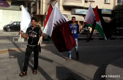 Palestinians carry the Qatari and Palestinian (red,black,white, green) flags in Gaza City on October 21, 2012, the day before the Emir of Qatar's official visit to the strip. Emir of Qatar Hamad bin Khalifa Al Thani visi...