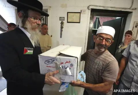 Members of Jewish Neturei Karta deliver humanitarian aid to Palestinian needy families in al-Tur neighborhood in Jerusalem on October. 21, 2012. Neturei Karta opposes Zionism and calls for a peaceful dismantling of the S...