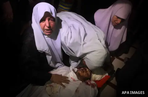Palestinian women mourn over the body of Abderahman Abu Jalaleh, 25, during his funeral in Beit Lahia, in the northern Gaza Strip, on October 22, 2012. An Israeli air strikes killed two Gaza militants as they clashed wit...